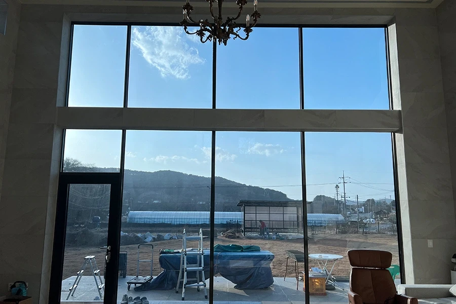 거실 실내에서 바라본 통유리창과 산 풍경